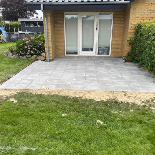 Belægning af ny terrasse i Hurup nær Thisted med lyse fliser, tilpasset husets stil og omgivelser